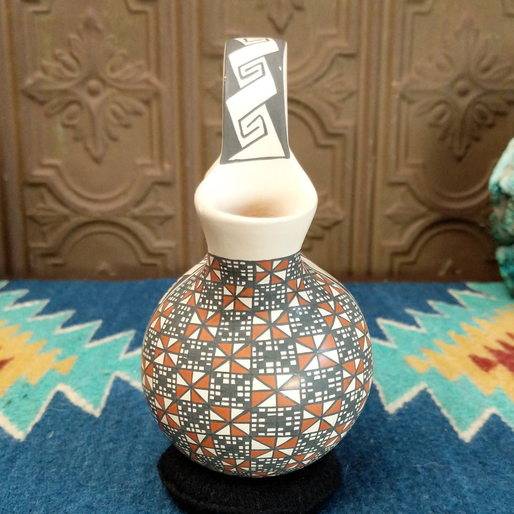 White clay wedding vase with traditionally colored geometric designs.