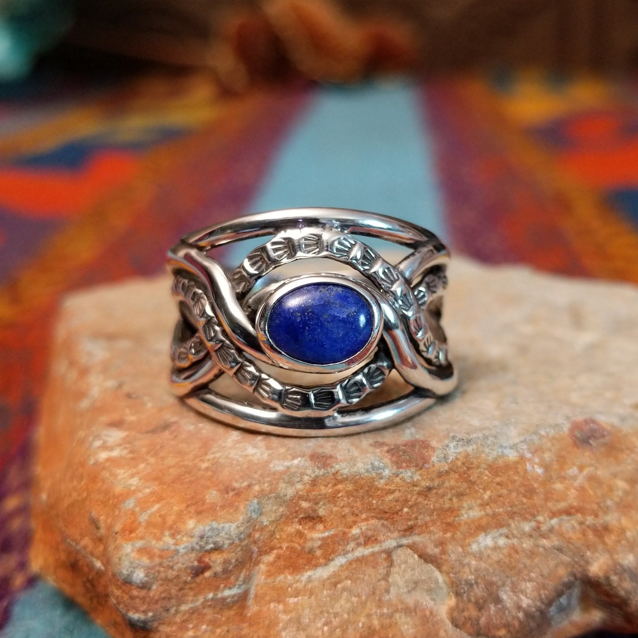 Meandering Lapis Ring by Raymond Coriz featuring an oval blue lapis stone set in Sterling Silver with flowing bands and detailed stamped silver accents.