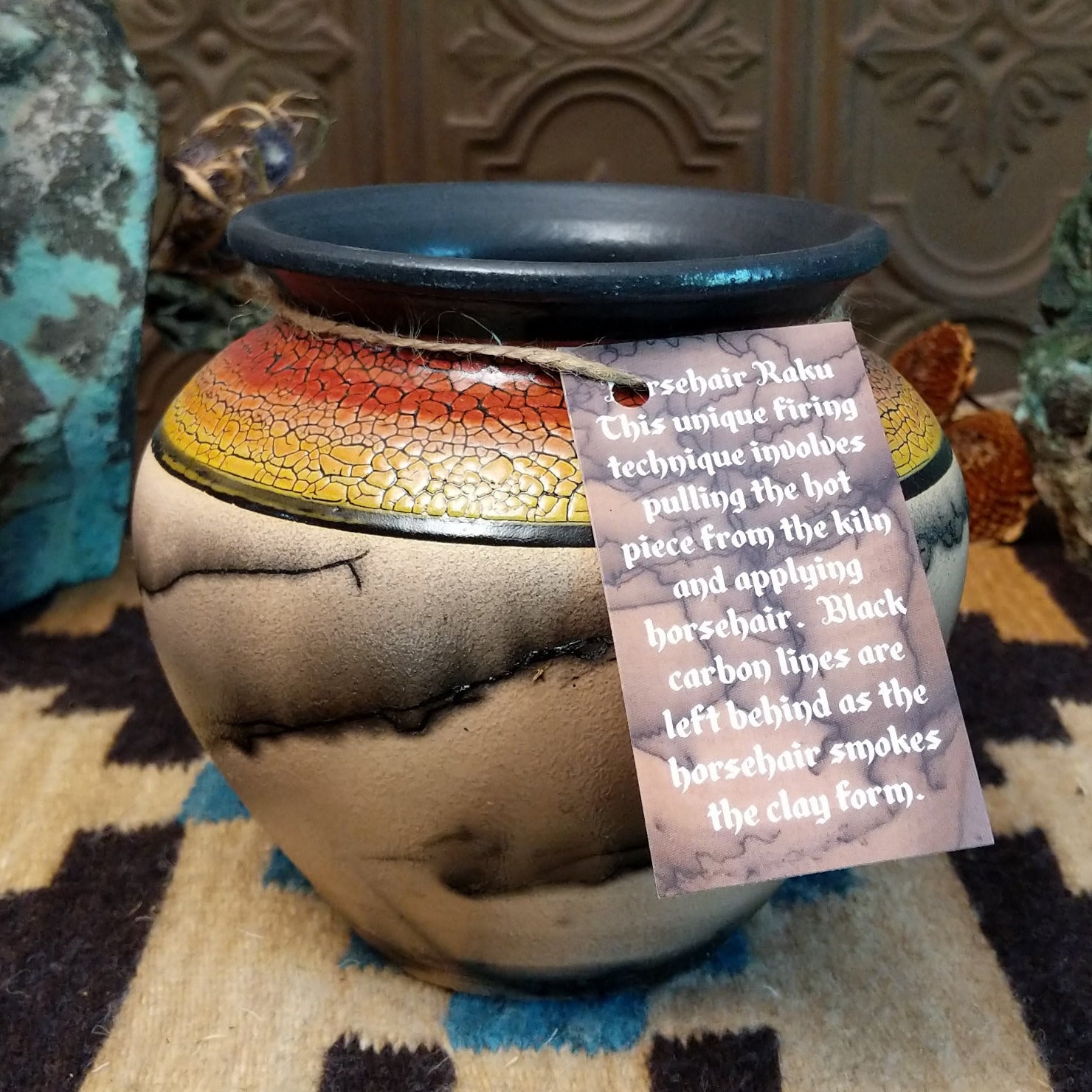 Ceramic pottery piece with horsehair fired onto the surface and sunset-colored top-half with crackled finish.