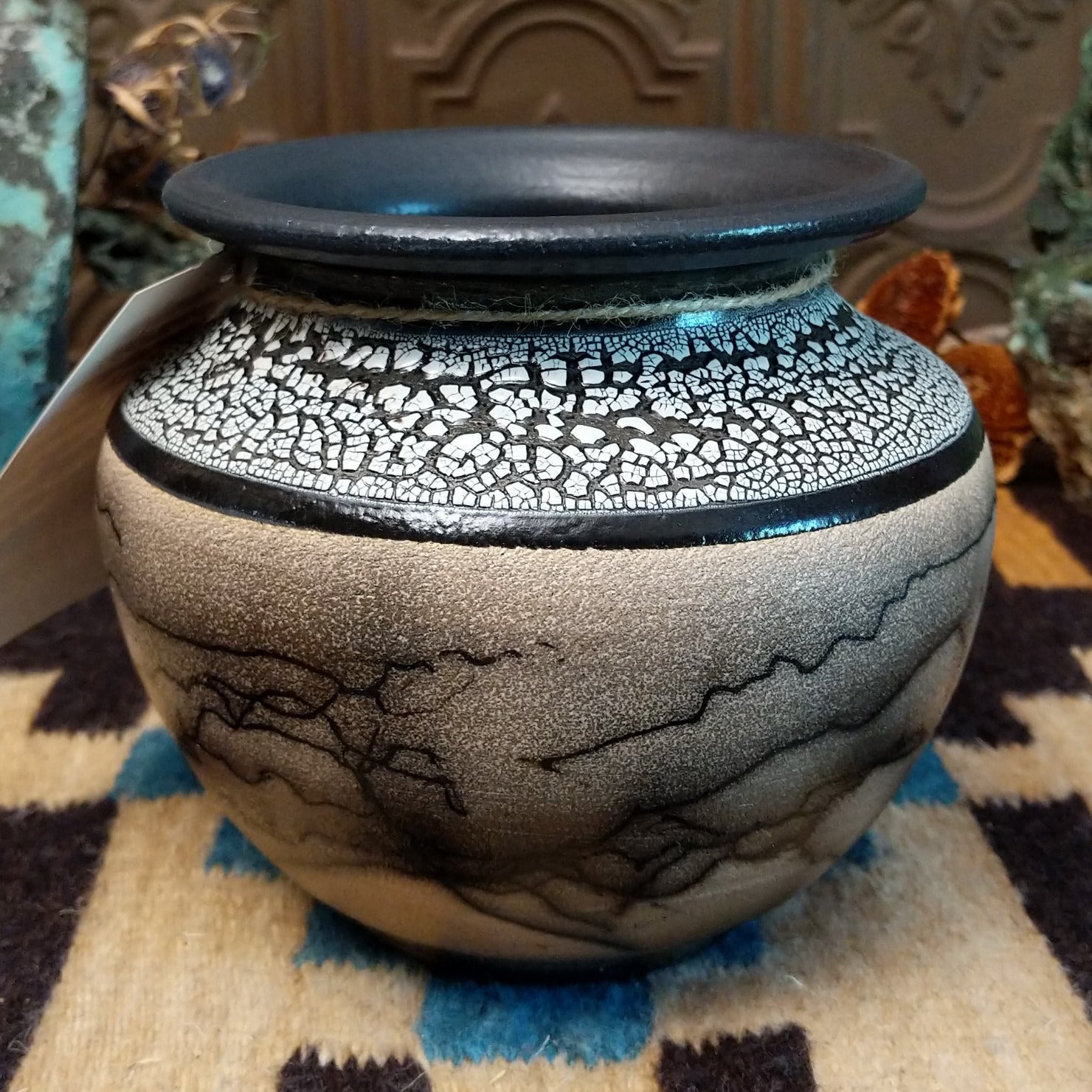 Ceramic pottery piece with horsehair fired onto the surface and white crackled glaze on the top-half.