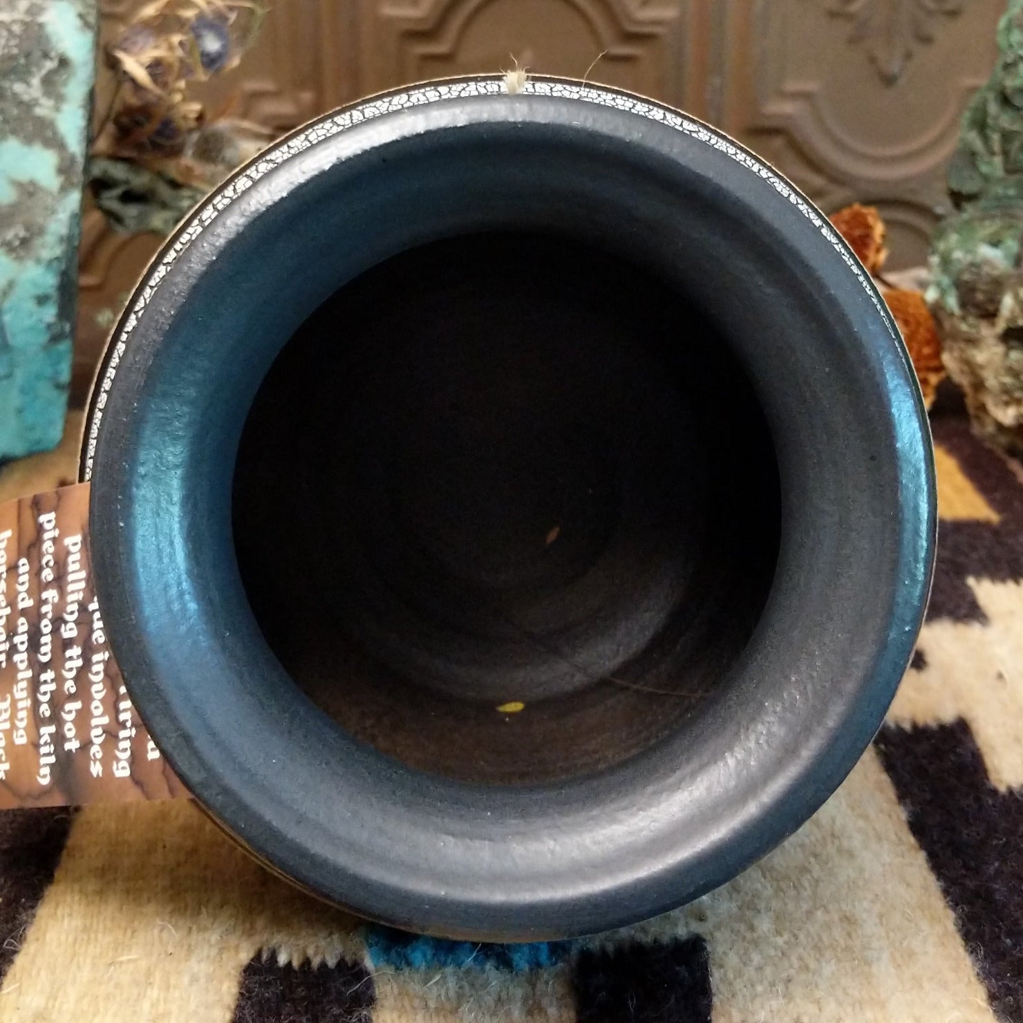 Close-up of the black-iip of the pot.