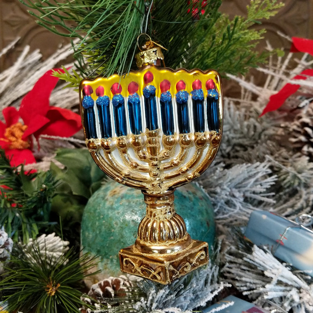 Glass made into a menorah in blue, gold, white, and red hues.