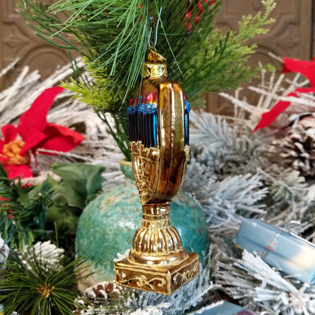 Glass made into a menorah in blue, gold, white, and red hues.