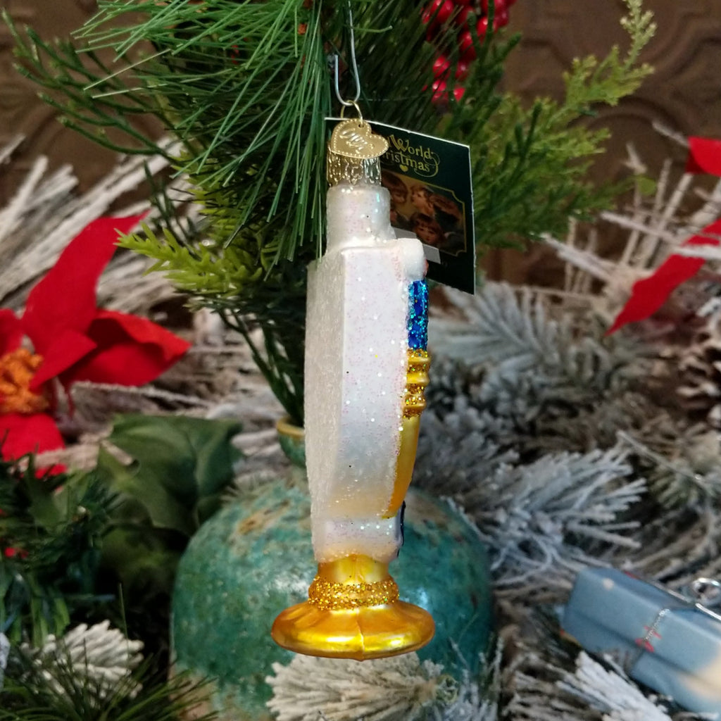Glass made into a menorah ornament in the colors gold, blue, and white.