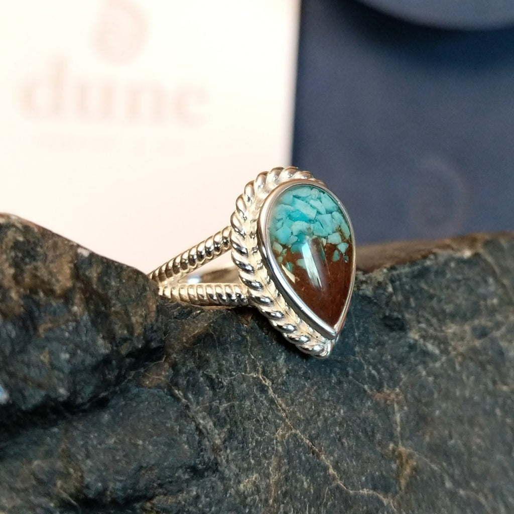 Mermaid ring with intricate band detailing featuring turquoise and Lake Powell sand set in the bezel.