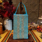 Mermaid Shimmer Club Bag by Bamboo Trading featuring an allover turquoise blue, silver, and gold beaded mermaid-scale pattern with shimmering metallic accents, a compact rectangular silhouette, and a coordinating turquoise blue shoulder strap.