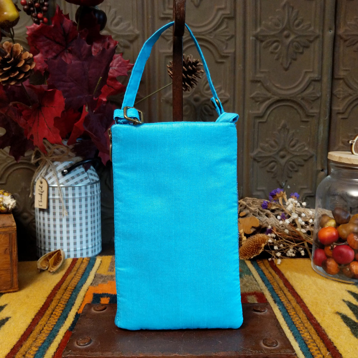 Mermaid Shimmer Club Bag by Bamboo Trading featuring an allover turquoise blue, silver, and gold beaded mermaid-scale pattern with shimmering metallic accents, a compact rectangular silhouette, and a coordinating turquoise blue shoulder strap; back view.