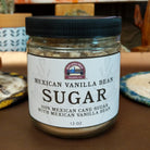 Jar of Mexican Vanilla Bean Sugar featuring fine sugar blended with real vanilla bean specks. Gourmet sweetener with the rich aroma and smooth flavor of authentic Mexican vanilla, ideal for baking and beverages.