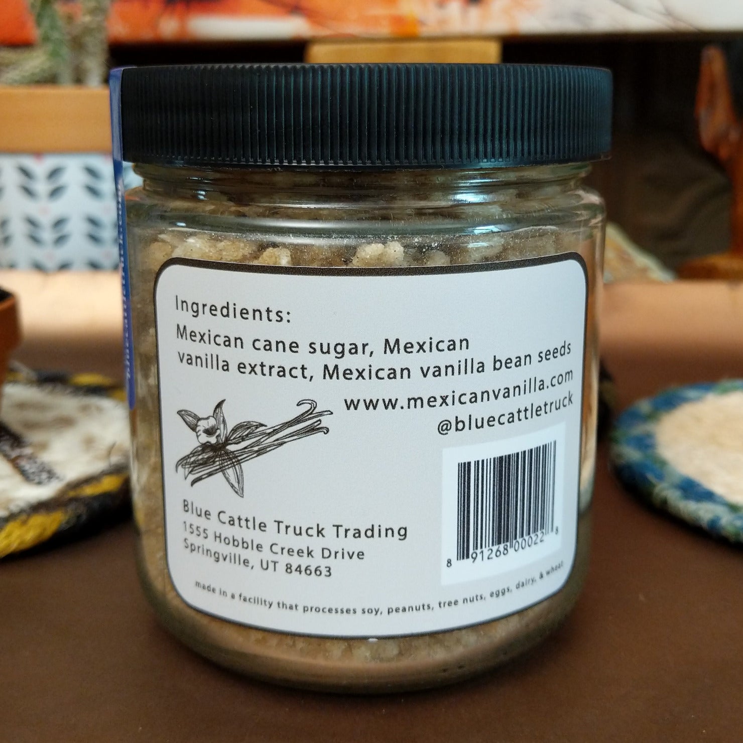 Jar of Mexican Vanilla Bean Sugar featuring fine sugar blended with real vanilla bean specks. Gourmet sweetener with the rich aroma and smooth flavor of authentic Mexican vanilla, ideal for baking and beverages.