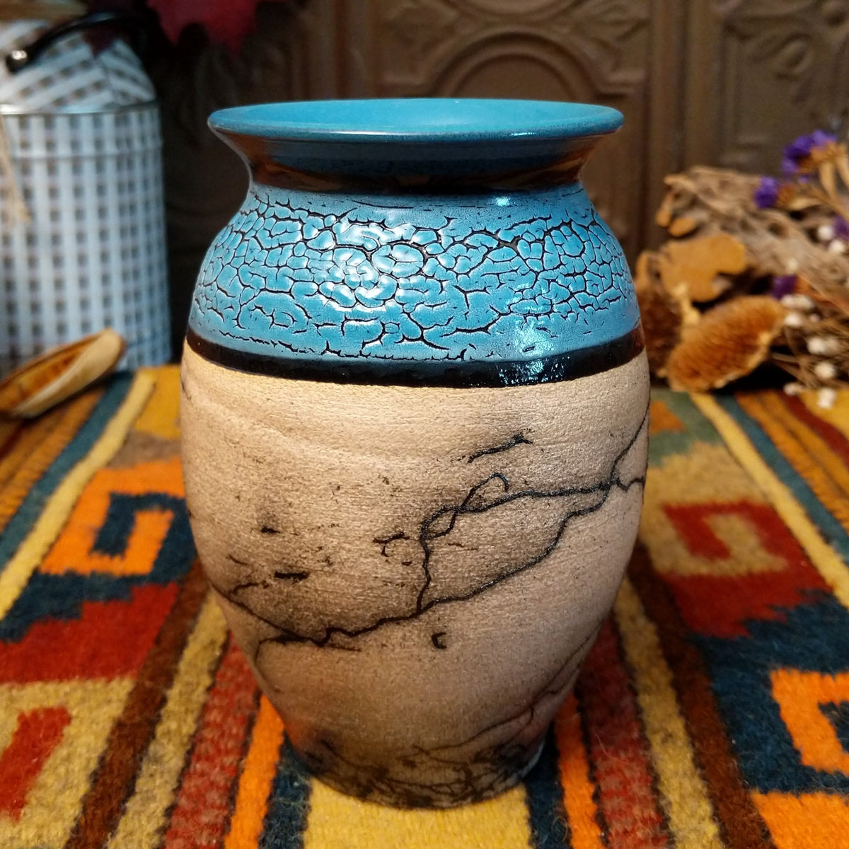 Mini horsehair pottery vase by Roger Calhoun with a flared turquoise-blue rim, crackled blue upper section, and black horsehair markings across a natural clay body.