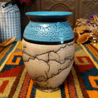 Mini horsehair pottery vase by Roger Calhoun with a flared turquoise-blue rim, crackled blue upper section, and black horsehair markings across a natural clay body.