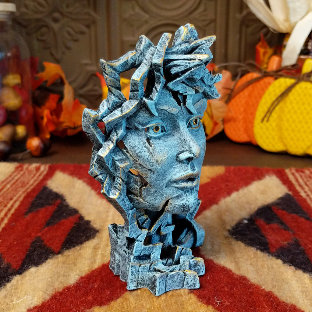 Cast marble creating an abstract face with detailed sculpting in the color gray.