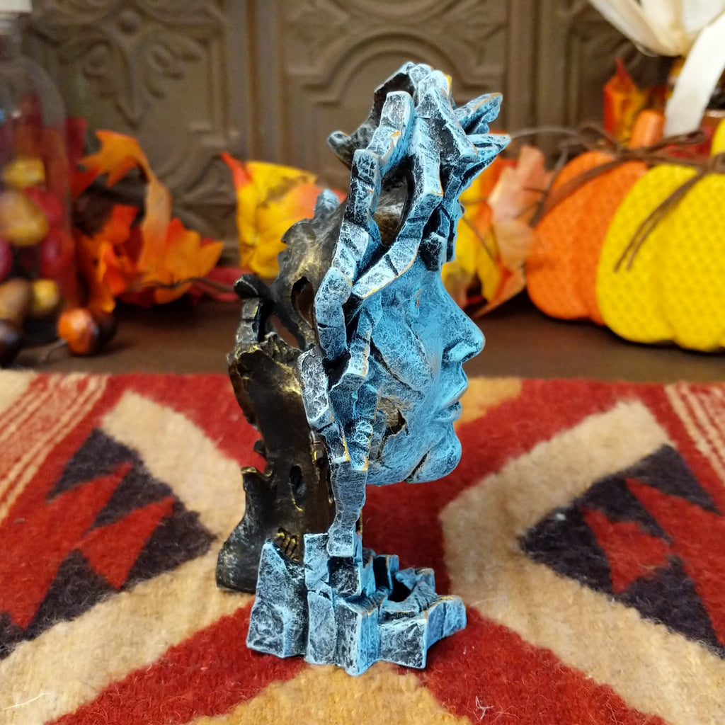 Cast marble creating an abstract face with detailed sculpting in the color gray.