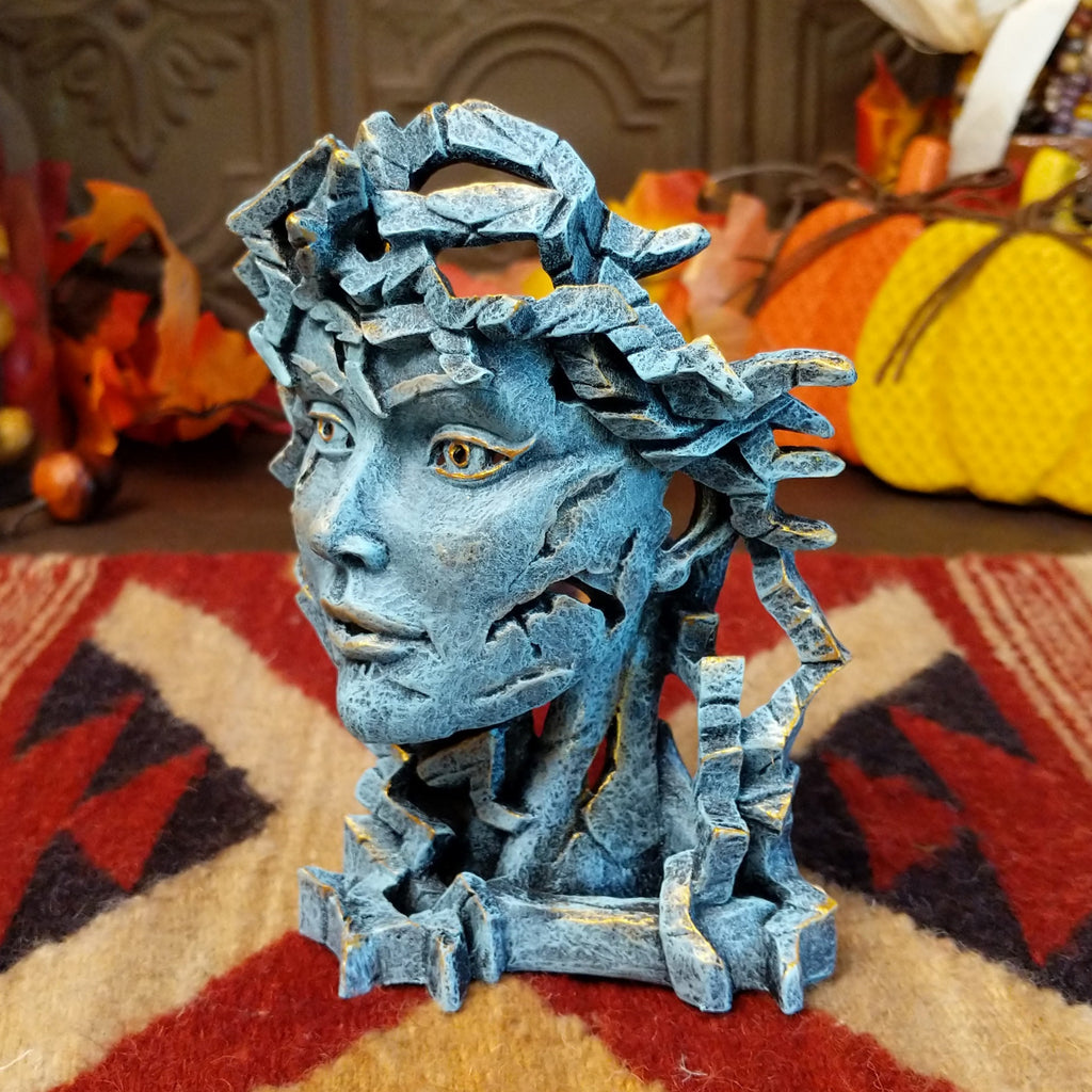 Cast marble creating an abstract face with detailed sculpting in the color gray.