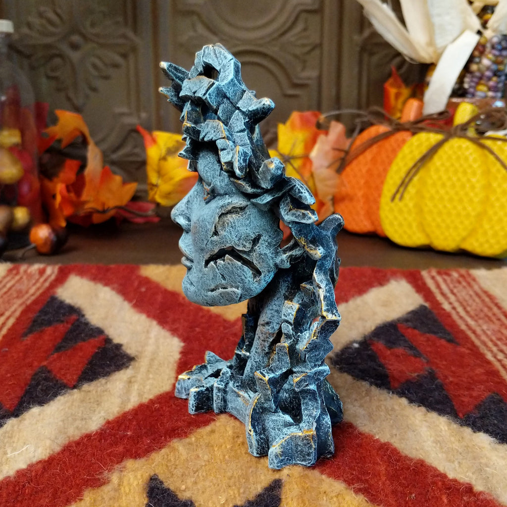 Cast marble creating an abstract face with detailed sculpting in the color gray.