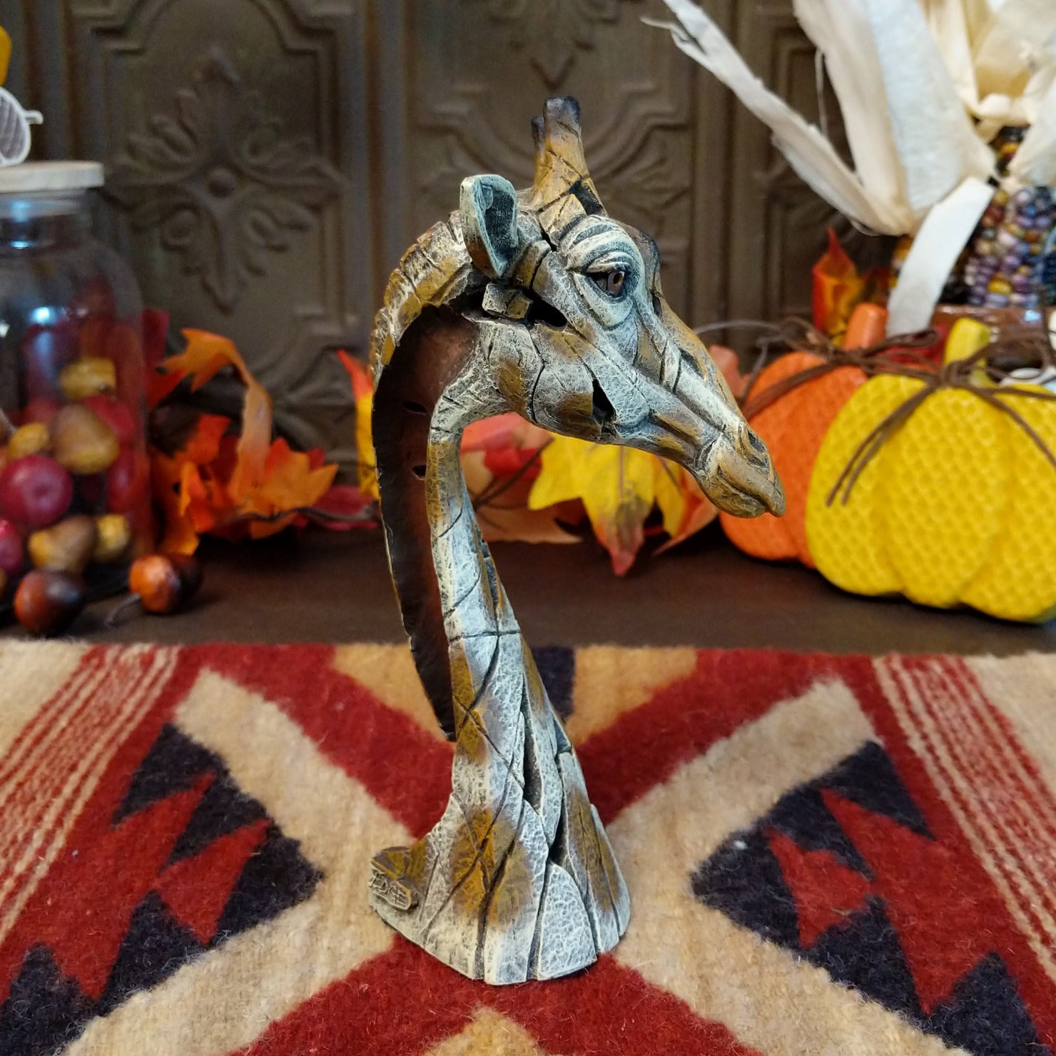 Cast marble used to create a miniature giraffe head painted in traditional colors representing the animal.