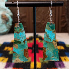 Mohave Turquoise Slab Earrings by Jameson Pete featuring elongated geometric turquoise stones with blue, green, tan, and brown matrix, suspended from silver hooks.
