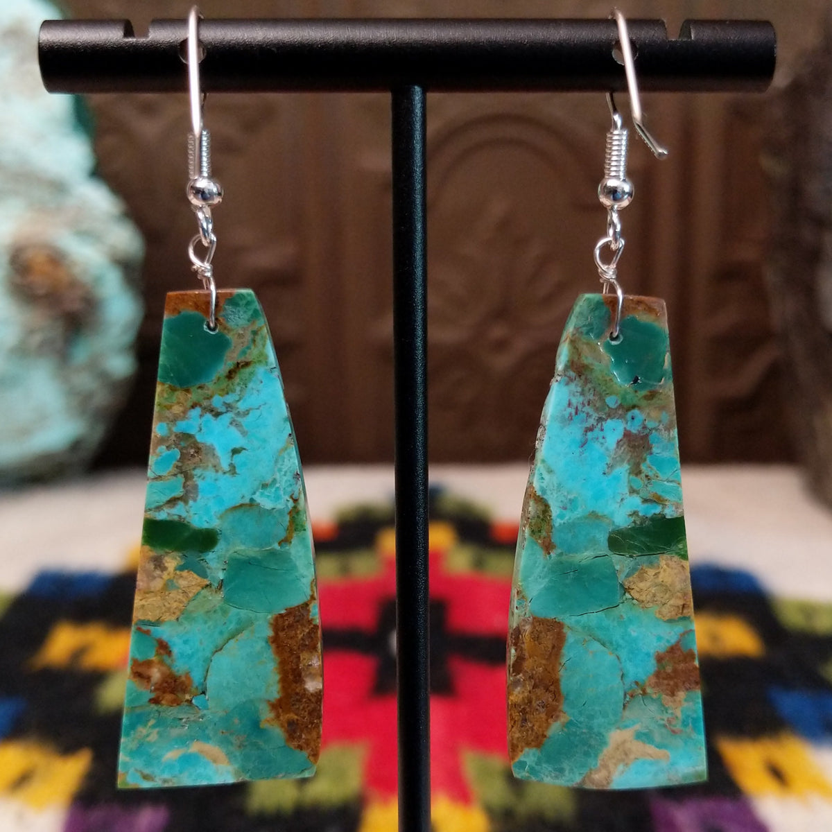 Mohave Turquoise Slab Earrings by Jameson Pete featuring elongated geometric turquoise stones with blue, green, tan, and brown matrix, suspended from silver hooks; backside view.