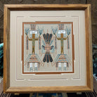 Framed Navajo sand painting of a Moon Yei with mirrored Yei figures and feather details. 