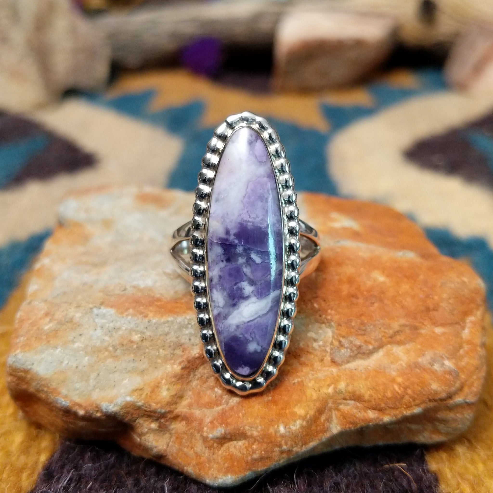 Handcrafted sterling silver ring featuring an elongated marquise-shaped Morado Opal cabochon with swirling shades of lavender, deep purple, and creamy white, set in a polished sterling silver beaded bezel.