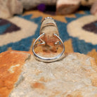 Handcrafted sterling silver ring featuring an elongated marquise-shaped Morado Opal cabochon with swirling shades of lavender, deep purple, and creamy white, set in a polished sterling silver beaded bezel; underside view.