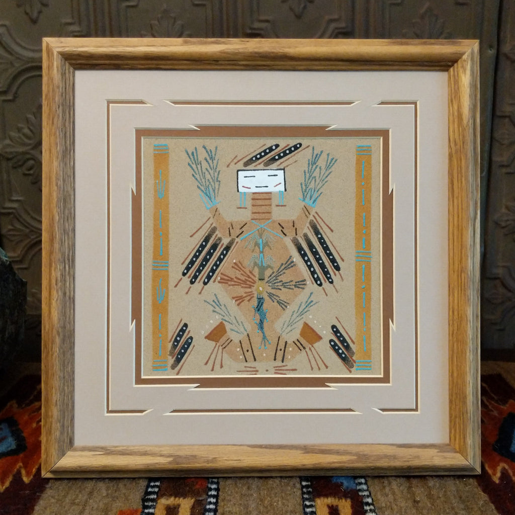 Sand used to depict a painting of Mother Earth with multicolored sand and set within a wooden frame.