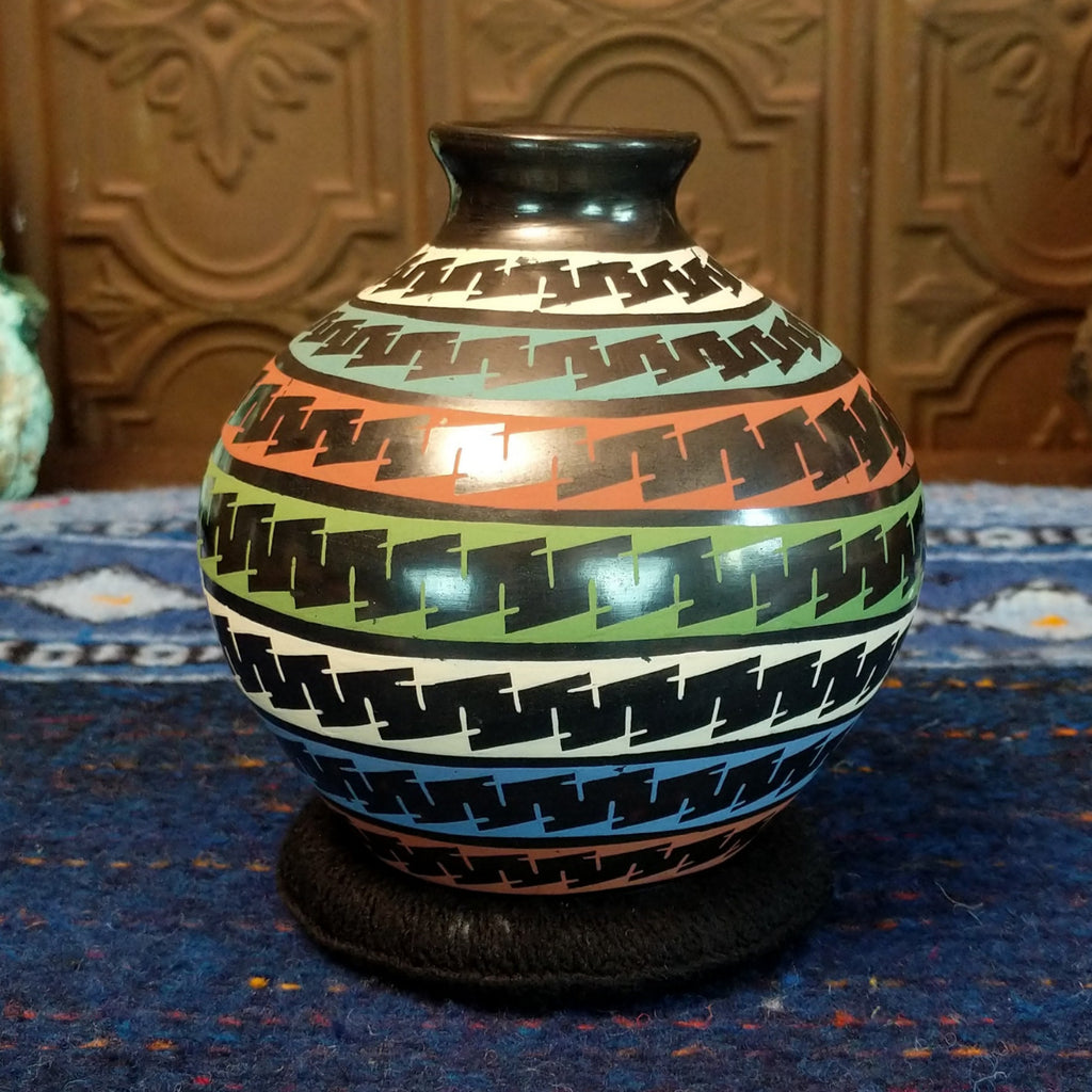 Glazed black clay with multi-color stripes and geometric patterns.