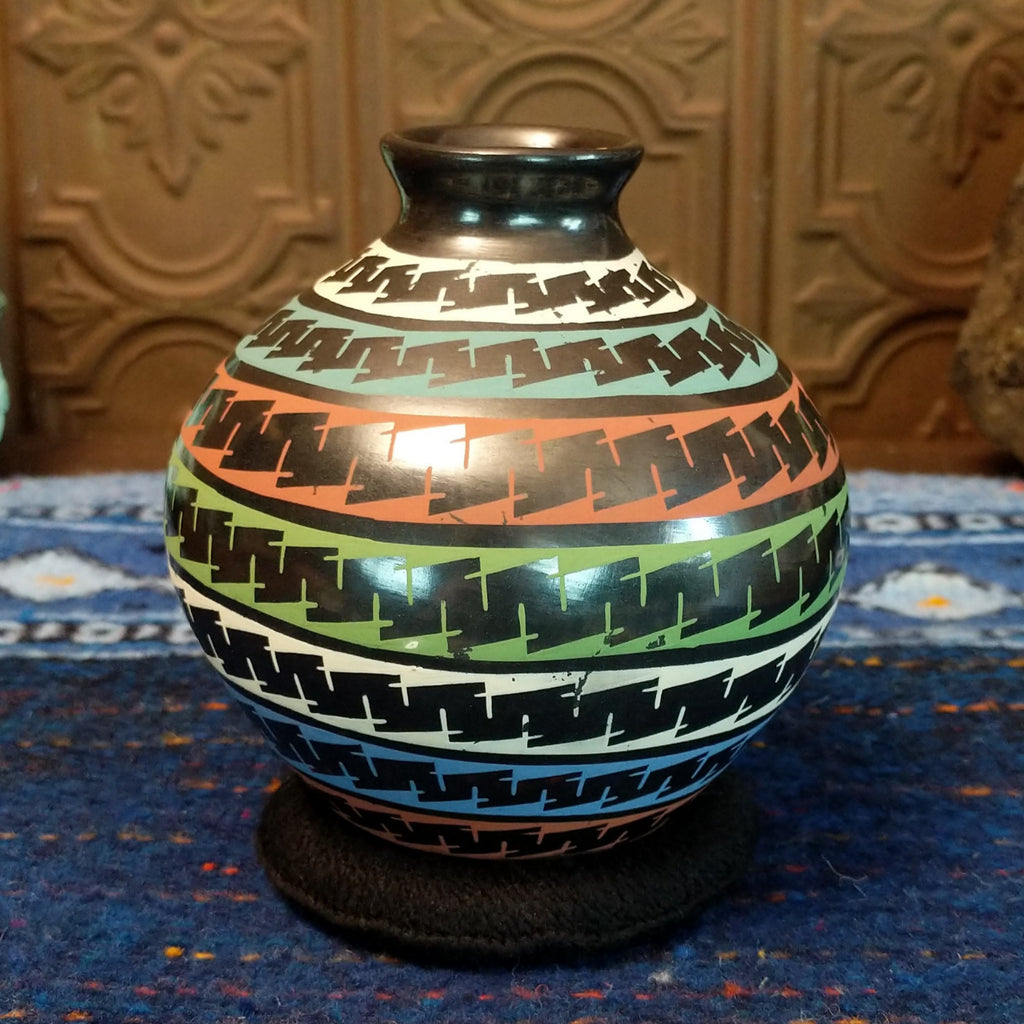 Glazed black clay with multi-color stripes and geometric patterns.