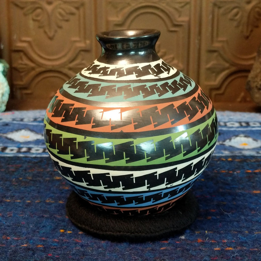 Glazed black clay with multi-color stripes and geometric patterns.