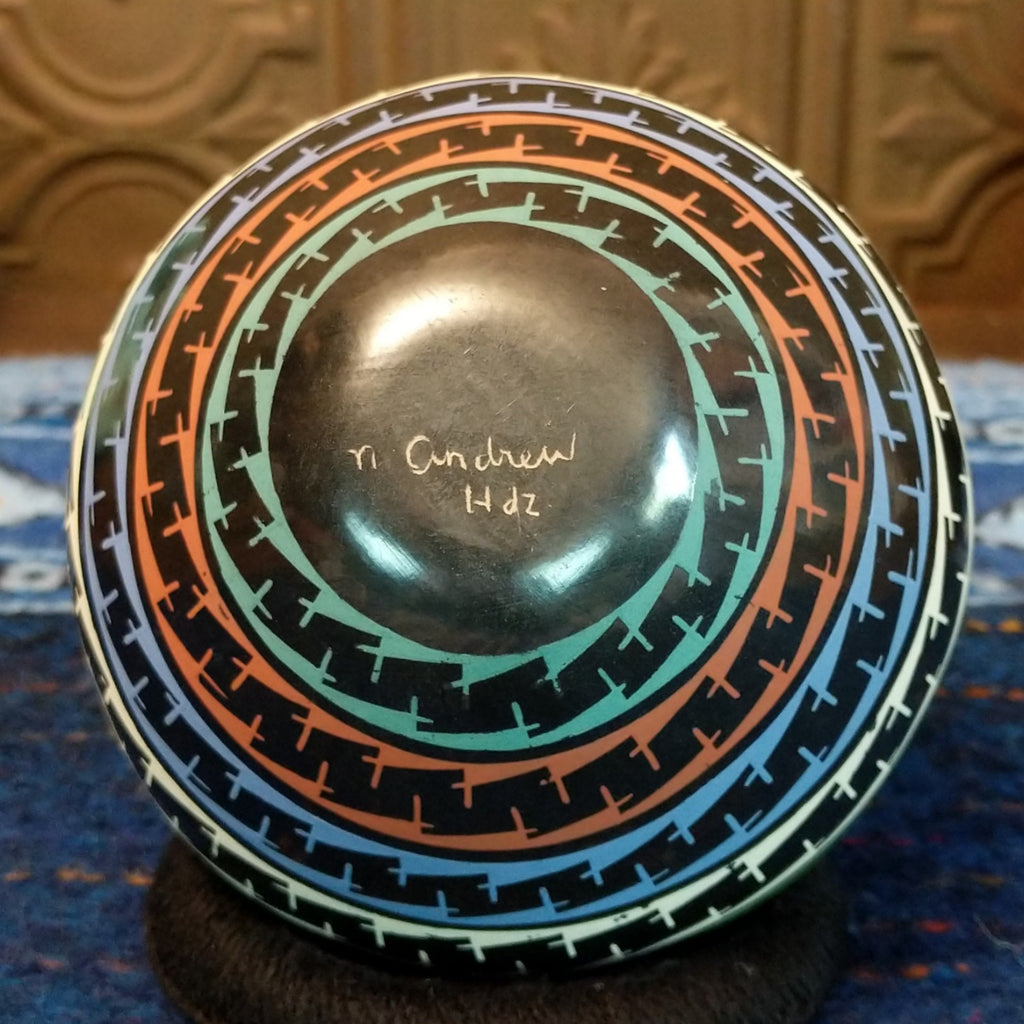 The artisan's signature is etched onto the base of the pot.