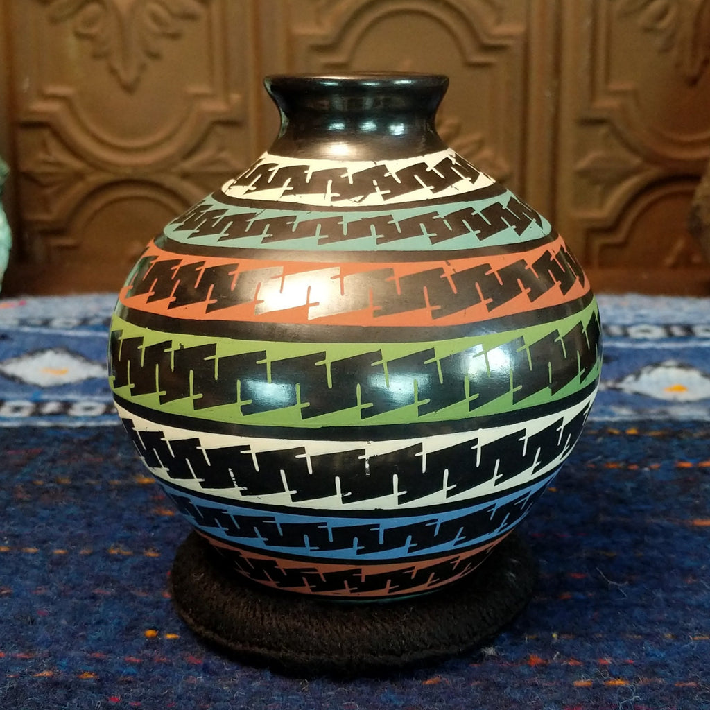 Glazed black clay with multi-color stripes and geometric patterns.