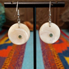 Close up of earring posts and artist's signature