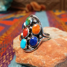 Multistone Cluster Ring by Raymond Coriz featuring turquoise, coral, lapis, and orange-toned stones set in Sterling Silver with polished silver bead accents; side view.