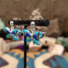 Handcrafted Navajo sterling silver dragonfly earrings by O. James featuring colorful multistone inlay wings in a polished silver dangle design; side view.