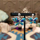 Handcrafted Navajo sterling silver dragonfly earrings by O. James featuring colorful multistone inlay wings in a polished silver dangle design.; side view.