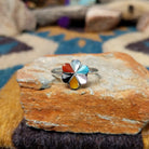 Handcrafted Zuni sterling silver flower ring by Raymond Bobelu featuring a six-petal multistone inlay design with turquoise, coral, black onyx, mother of pearl, and yellow mussel shell.