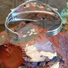 Sterling silver cuff bracelet with horse motif and turquoise, peridot, and amethyst set in bezels.