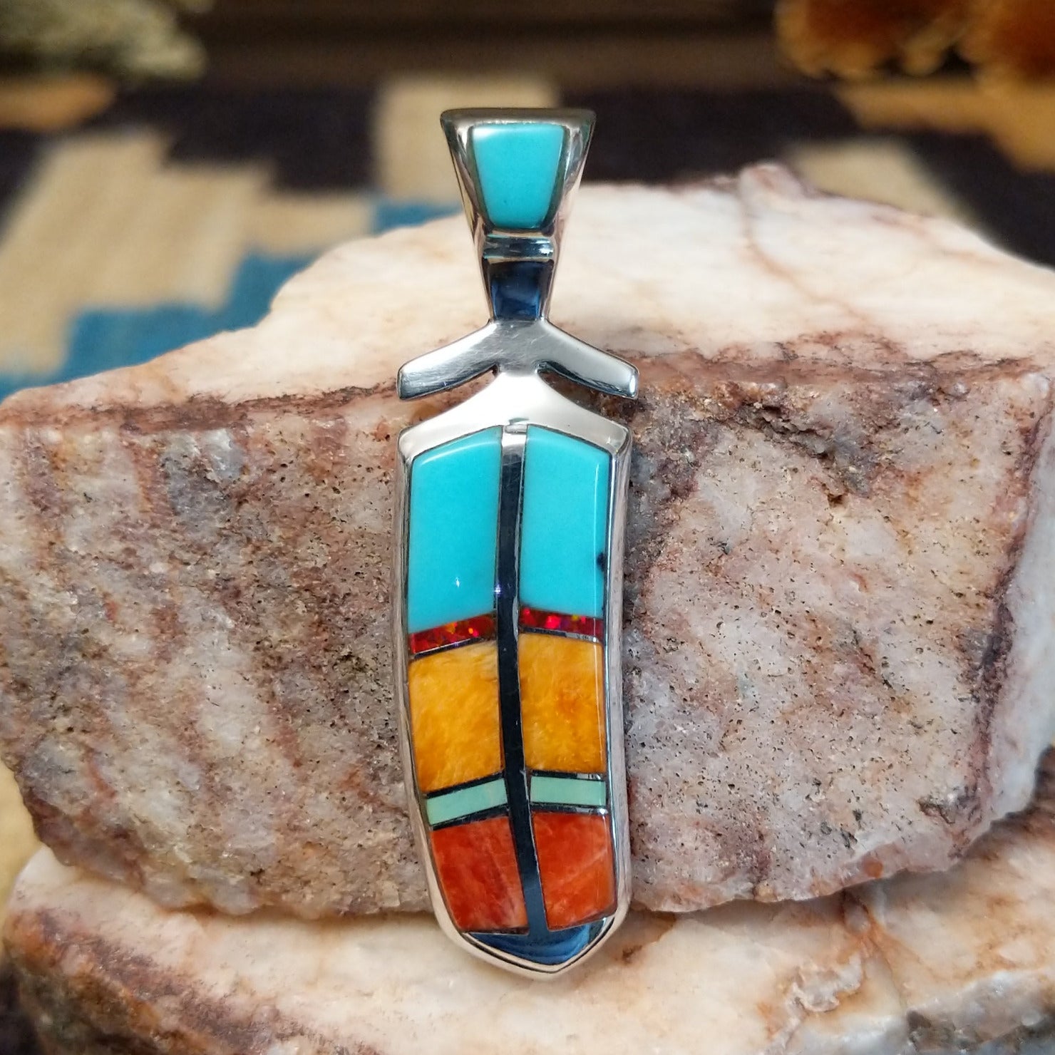 Sterling silver feather pendant with multistone inlay.