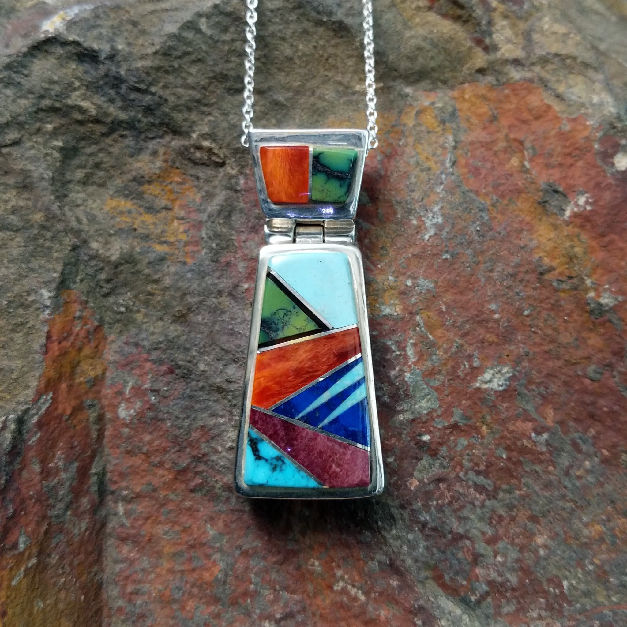 Handcrafted sterling silver multistone inlay pendant by Valerie Yazzie, featuring a colorful geometric inlay design with an articulated two-piece pendant.