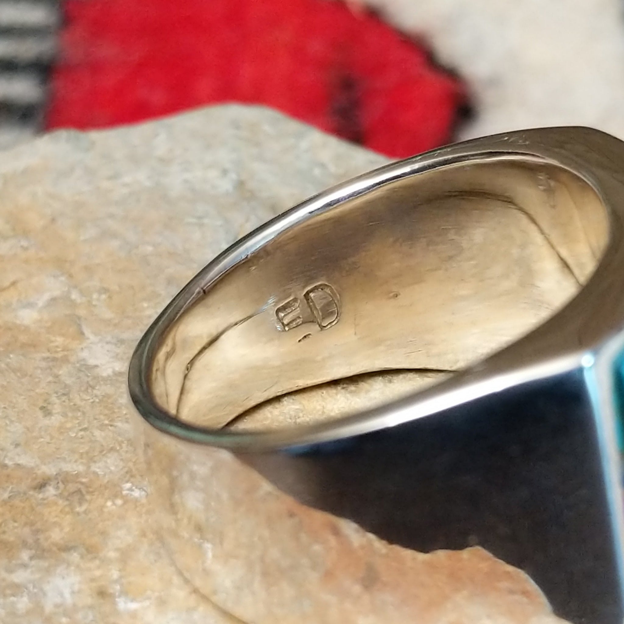 Multistone inlay ring by E.D. featuring geometric turquoise, blue, purple, black, and light-colored stones separated by fine silver channels in a wide polished silver setting; artisan stamp.