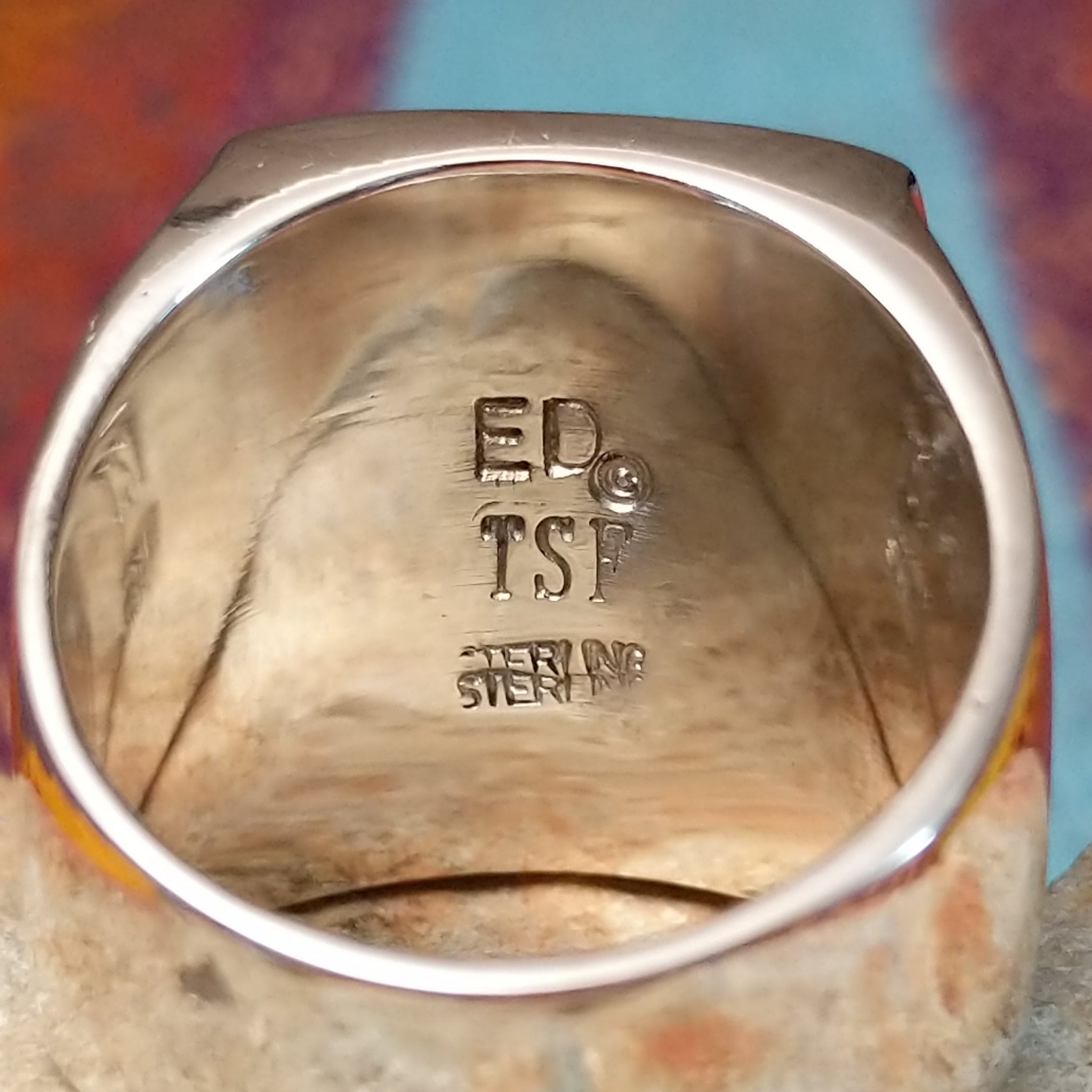 Multistone Inlay Ring by E.D. featuring a large rectangular face with geometric turquoise, blue, purple, cream, and multicolored stone inlay separated by fine silver channels; artisan and Sterling Silver stamp.