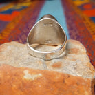 Multistone Inlay Ring by Wilbert Grey featuring an oval geometric design of orange, turquoise, and deep blue stones separated by fine silver channels in a polished silver setting; underside view.