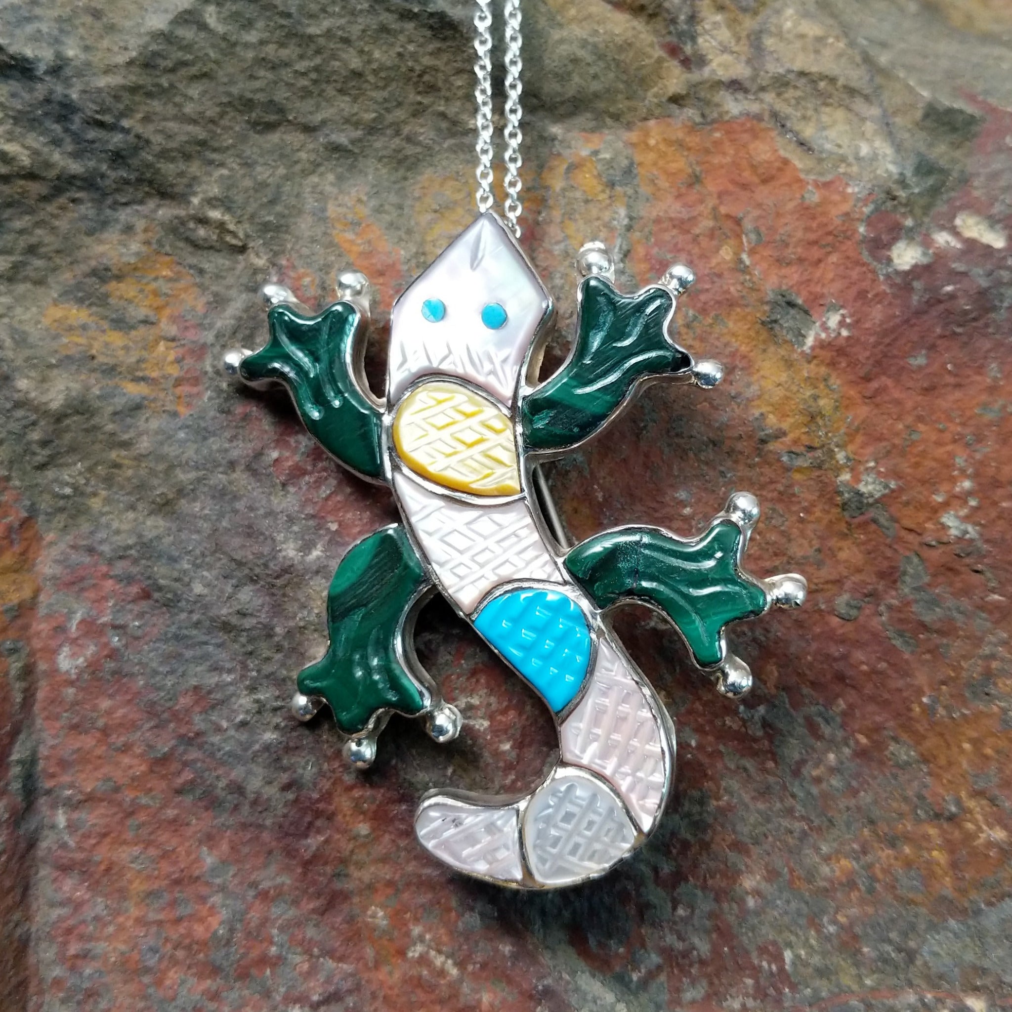 Handcrafted sterling silver multistone lizard pin and pendant by Tamara Pinto, featuring traditional Zuni inlay in a colorful lizard design.