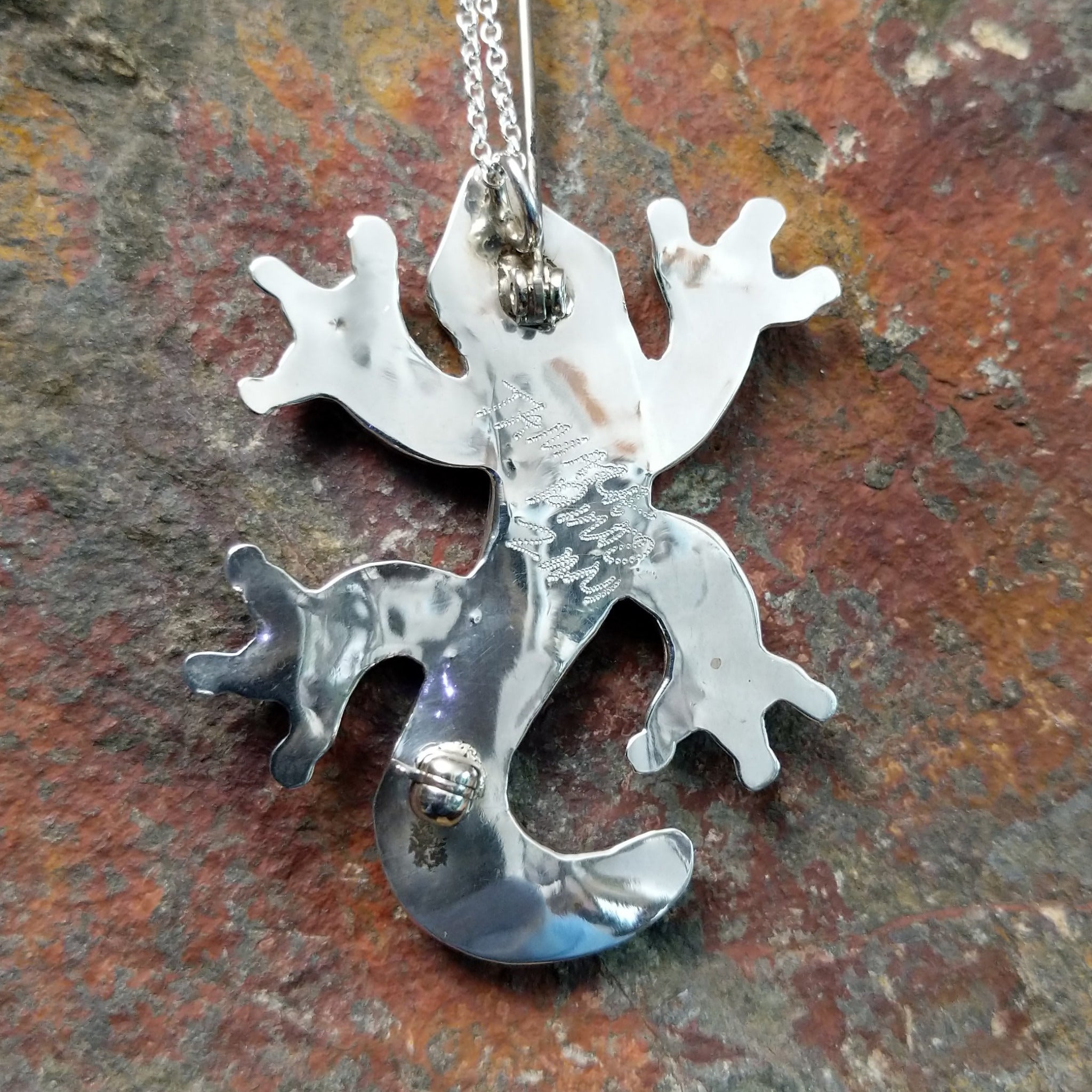 Handcrafted sterling silver multistone lizard pin and pendant by Tamara Pinto, featuring traditional Zuni inlay in a colorful lizard design; artisan signature.