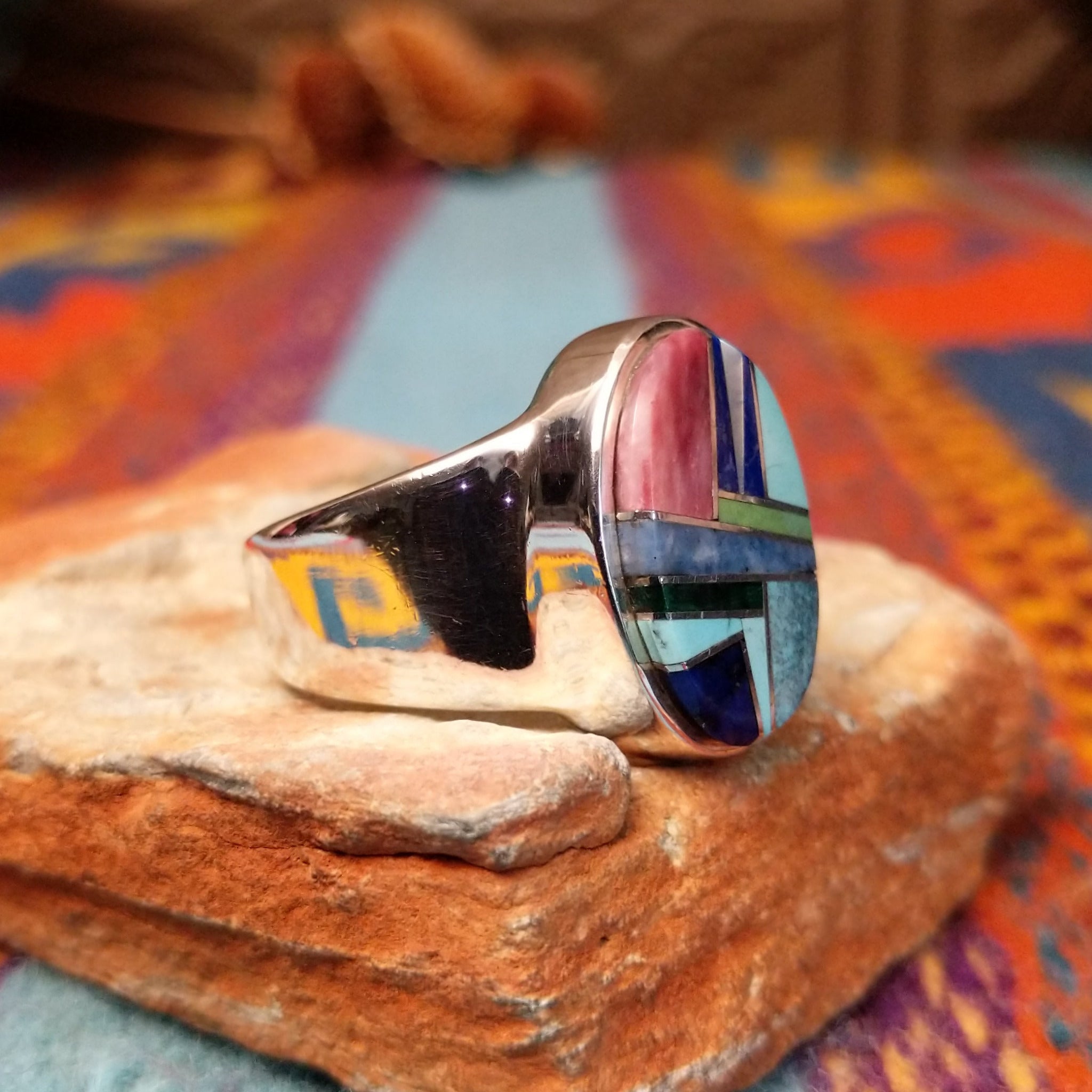 Multistone Oval Inlay Ring by E.D. featuring a geometric mosaic of stones separated by fine silver channels in a polished silver setting; side view.