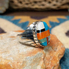 Handcrafted sterling silver oval inlay ring by Rex Abeita in a colorful geometric mosaic set in a polished silver bezel; side view.