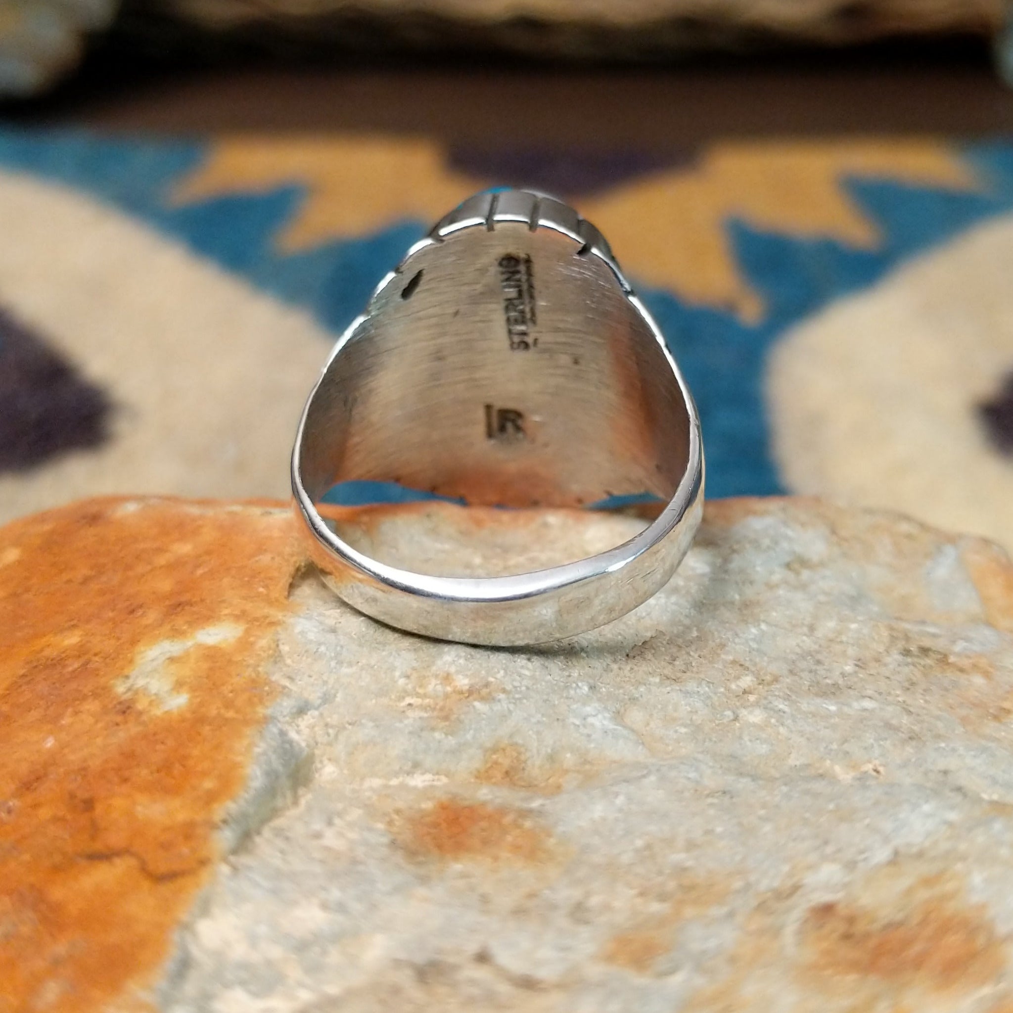Handcrafted sterling silver oval inlay ring by Rex Abeita in a colorful geometric mosaic set in a polished silver bezel; underside view.