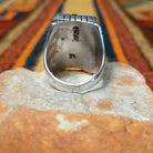 This vibrant Multistone Rectangle Inlay Ring by Wilbert Grey features a geometric arrangement of turquoise, coral, black, and white stone inlays set in a rectangular silver face with a detailed band; underside view.