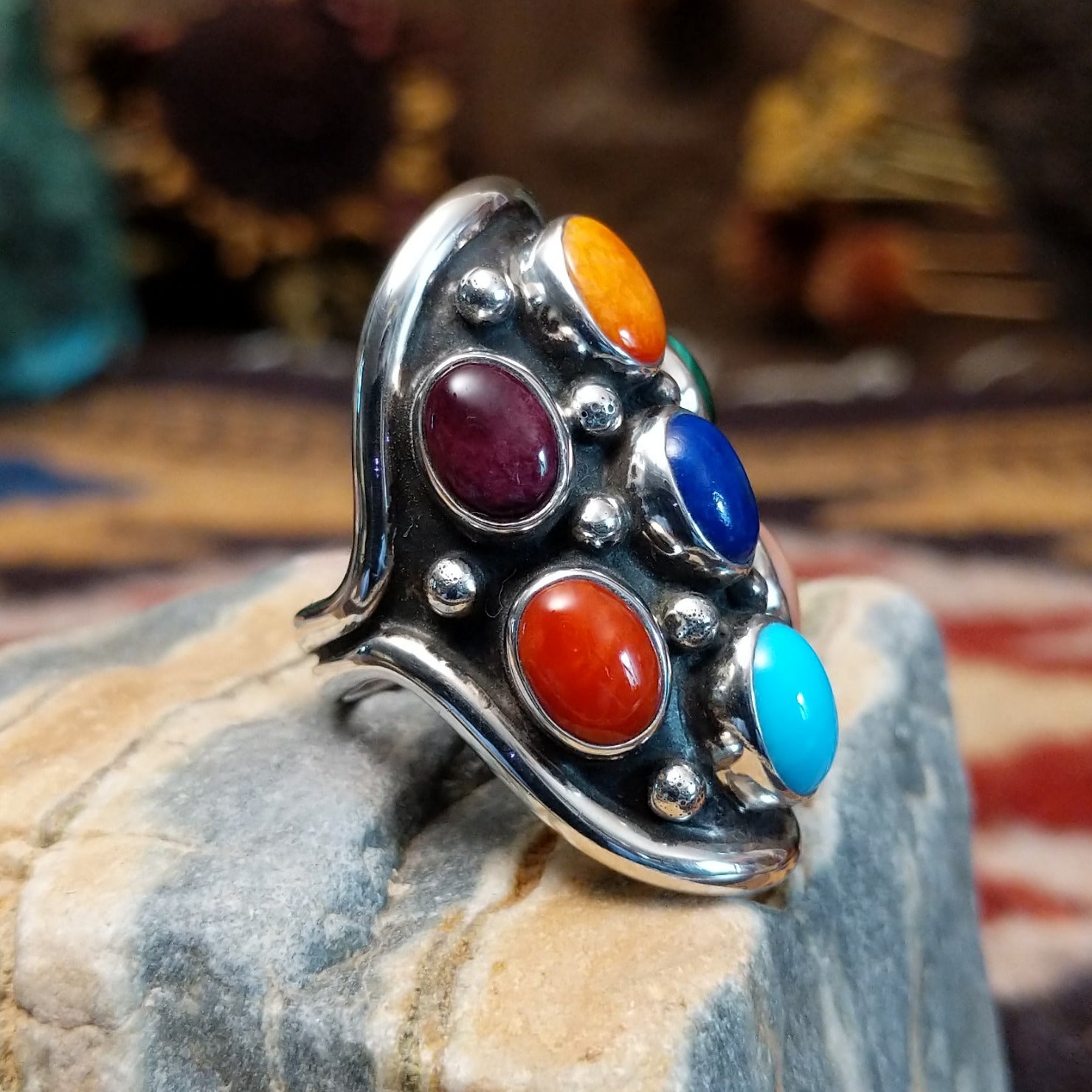 Handcrafted sterling silver multistone ring by Bernice Bonney featuring a colorful arrangement of natural gemstones in a traditional Southwestern Native American design.  Side view.
