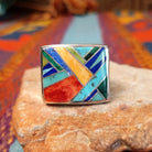 Multistone Square Inlay Ring by O.J. featuring colorful geometric turquoise, blue, red, yellow, and green stone inlay separated by Sterling Silver channels on a broad square face.